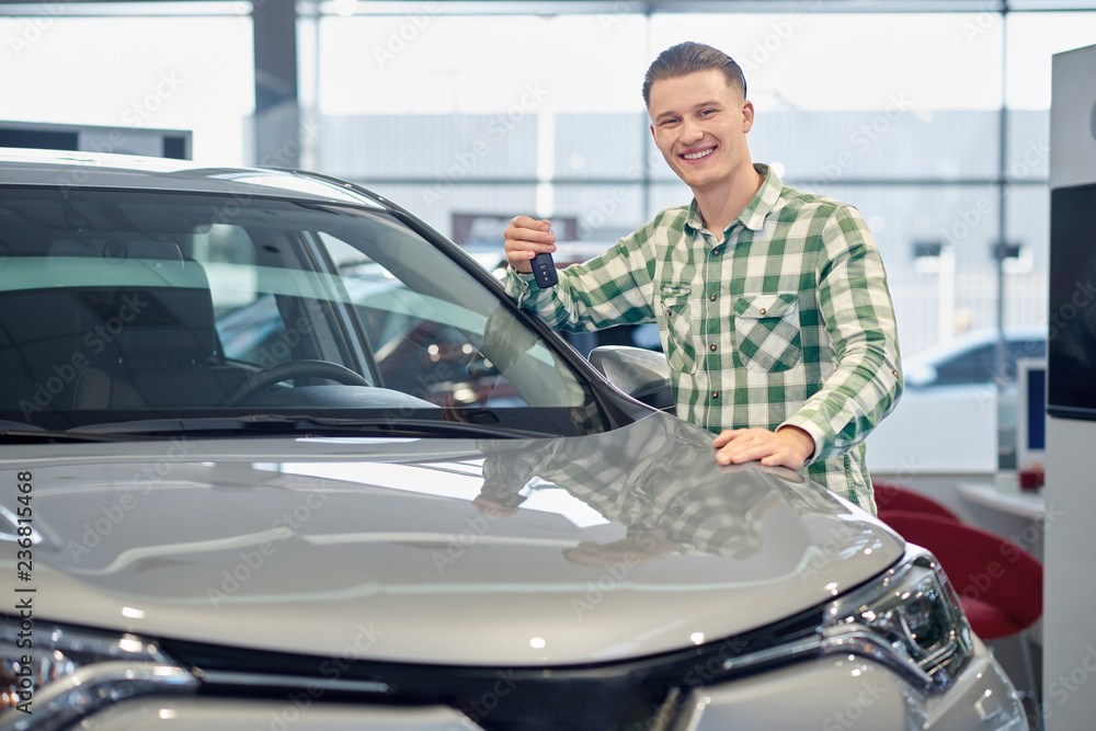 Blond handsome man buying grey vehicle in car salon. Blond handsome man buying grey vehicle in car salon.
