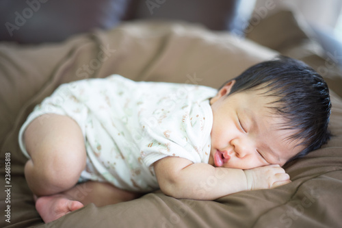 Infant sleep on gentle bed and look like she have a sweet dream
