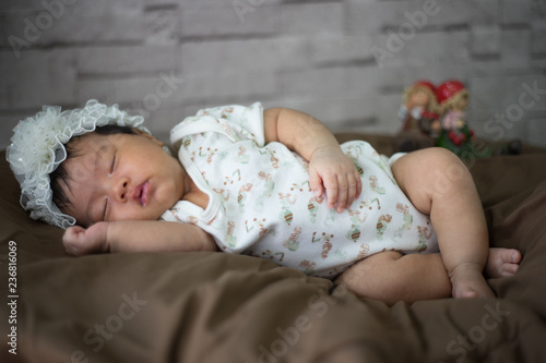 Infant sleep on gentle bed and look like she have a sweet dream