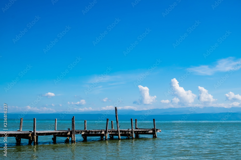 old wooden pier on the sea with blue sky