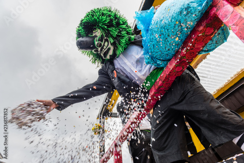 Waggis verteilt konfettie vom wagen an der Fasnacht