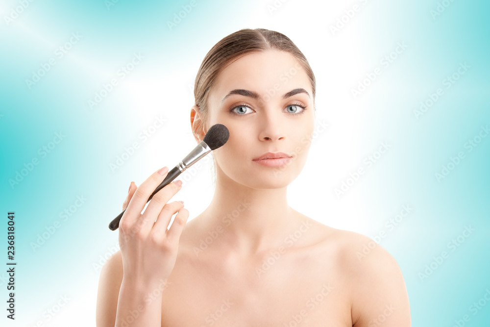 Young naked woman applying makeup. Studio shot. Young naked woman applying makeup. Studio shot.