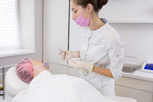 Cosmetologist making injection in face of senior woman. Skin aging, rejuvenation, face lifting procedures. Aged woman gets beauty facial injections in cosmetology clinic.