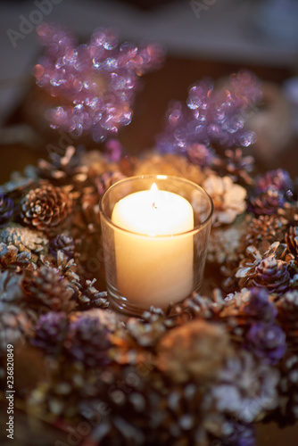 Advent decoration, wreath, candle. In the dark a candle in a beautiful decorative wreath is burning.