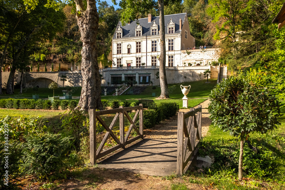 Chateau Gaillard Amboise surrounded by forest park with small bridge over a little stream on the foreground. Loire valley, France.