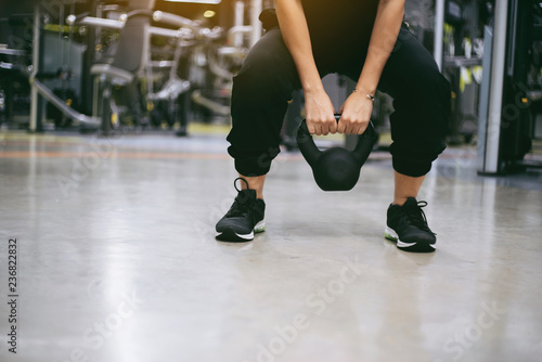 Woman having functional fitness training with kettlebell in sport gym weight lifting and legs squat healthy lifestyle bodybuilding. © lesterman