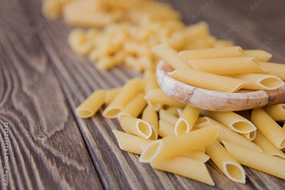 pasta of different types taken from the top and wooden spoon. Food background concept.