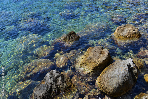 Colored pebbles under water at the coast of Mediterranean sea.