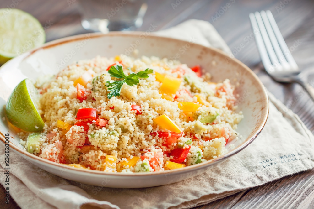Couscous salad with fresh red and yellow bell peppers, avocado, tomatoes and lime. The concept of vegetarian and healthy food. Couscous salad with fresh red and yellow bell peppers, avocado, tomatoes and lime. The concept of vegetarian and healthy food.