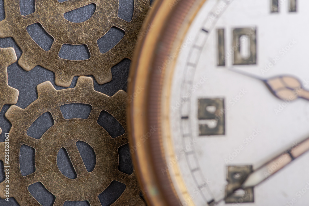 Obraz premium Antique pocket watch and old vintage hour metallic gears on natural stone background.
