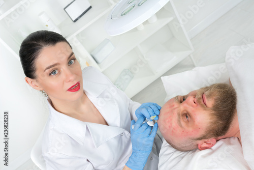 The doctor cosmetologist makes the Rejuvenating facial injections procedure for tightening and smoothing wrinkles on the face skin of a men in a beauty salon.Cosmetology skin care.