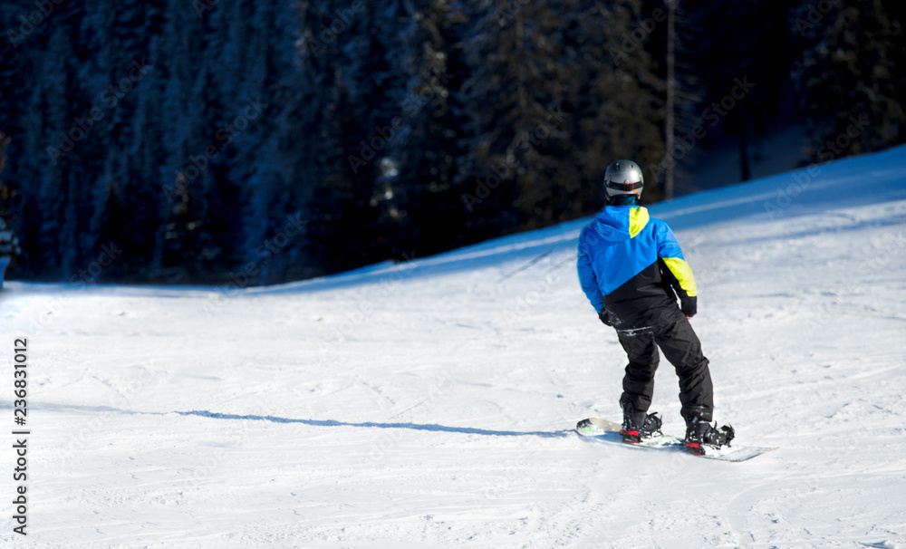 Snowboarder on snowboard  piste running downhill in beautiful Alpine landscape rides through snow, explosion . Freeride snowboarding in  Ski Resort on the slope
