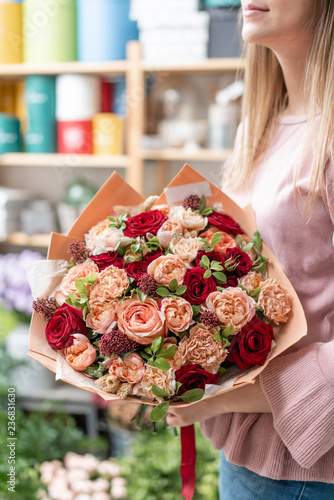 European floral shop. Bouquet of beautiful Mixed flowers in woman hand. Excellent garden flowers in the arrangement   the work of a professional florist.