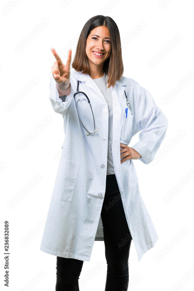 Doctor woman with stethoscope smiling and showing victory sign on isolated white background Doctor woman with stethoscope smiling and showing victory sign on isolated white background