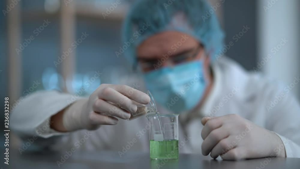 In a laboratory, a scientist with a pipette analyzes a green liquid to extract the DNA and molecules in the test tubes. Doctor working with liquid In a laboratory, a scientist with a pipette analyzes a green liquid to extract the DNA and molecules in the test tubes. Doctor working with liquid