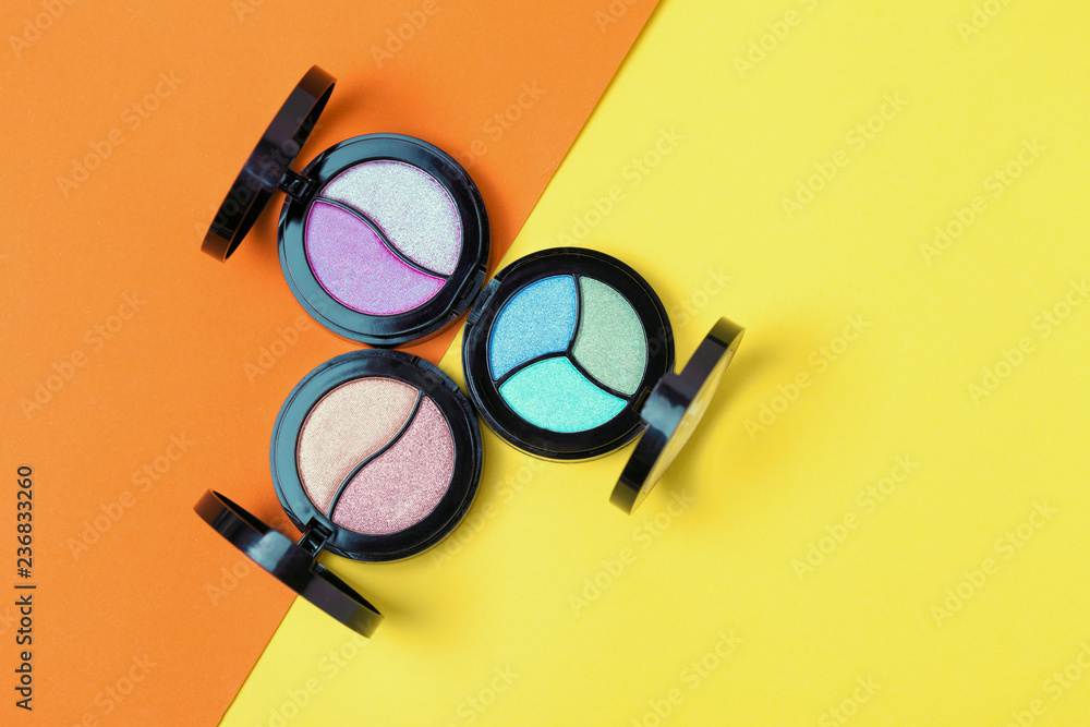 Top view of Three Eye shadows pallets on yellow and orange background. Fashion cosmetic set. Top view. Emty space for text. Copyspace Top view of Three Eye shadows pallets on yellow and orange background. Fashion cosmetic set. Top view. Emty space for text. Copyspace