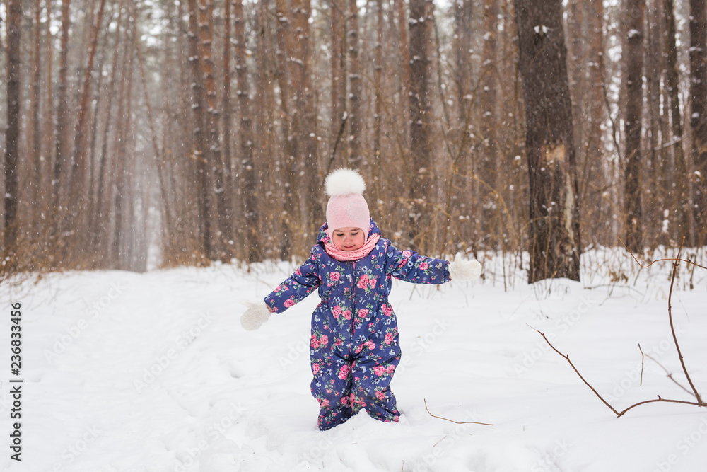 Childhood and children concept - baby girl walk in the winter outdoors Childhood and children concept - baby girl walk in the winter outdoors