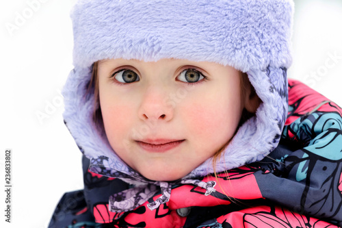 Portrait of a five year old beautiful girl in winter clothes, close-up