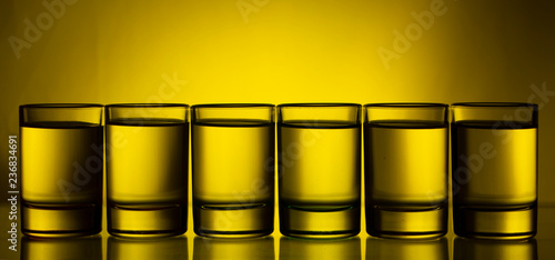 Six small multi-colored glasses on a bright background