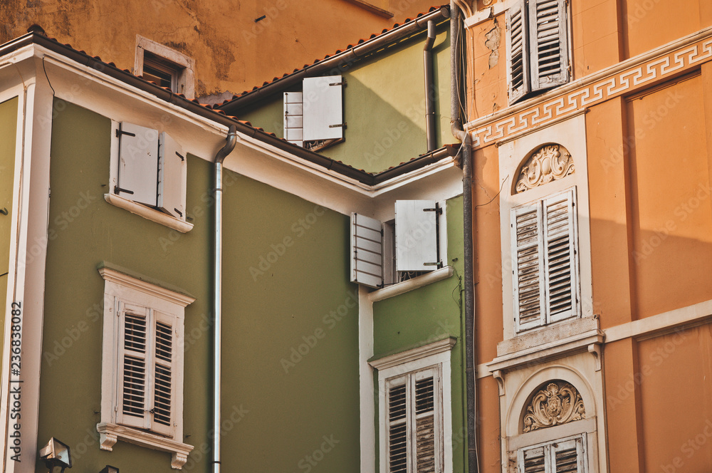 Beautiful colored old houses with stylish windows in the city of Piran. Architecture in the Adriatic. Travel to Slovenia