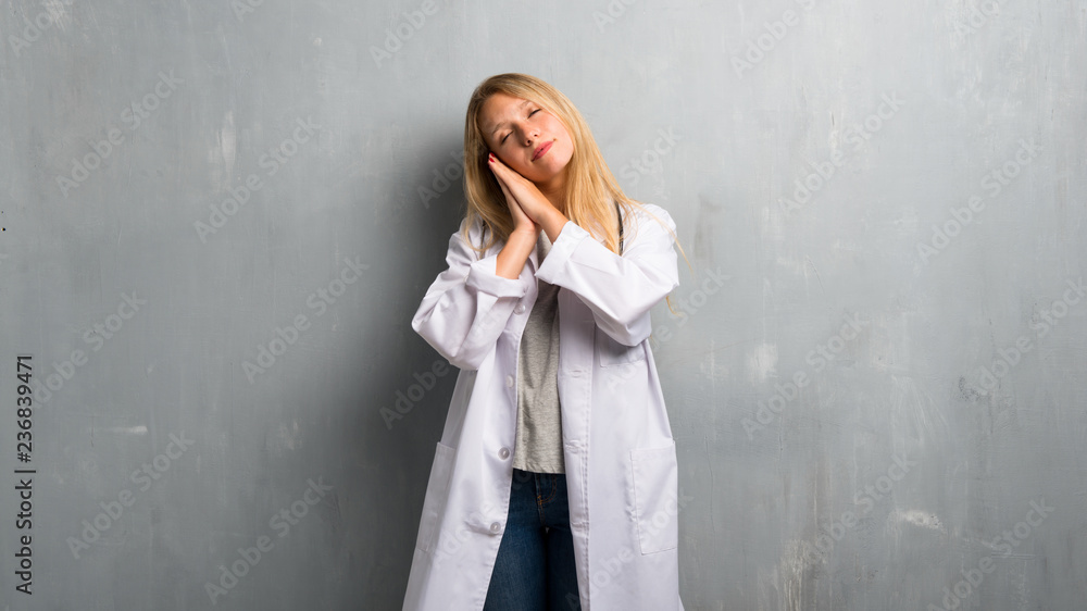 Fototapeta premium Young doctor woman making sleep gesture. Adorable sweet expression