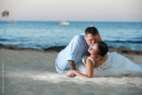 Photography Beautiful smiling young bride and groom walking on the beach, kissing and having fun, wedding ceremony near the rocks and sea