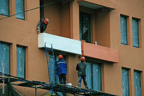 men painting the balcony of a new house