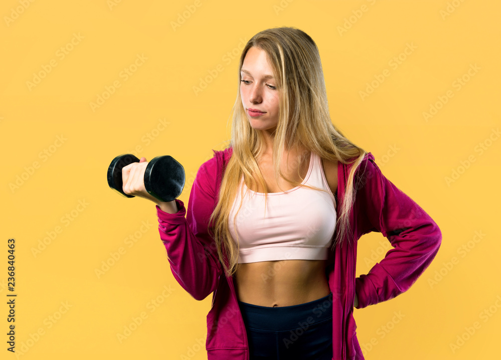Pretty sport woman making weightlifting on yellow background Pretty sport woman making weightlifting on yellow background