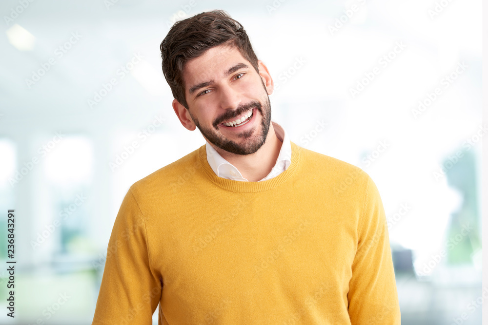 Handsome young man in casual clothes looking at camera and smiling Handsome young man in casual clothes looking at camera and smiling