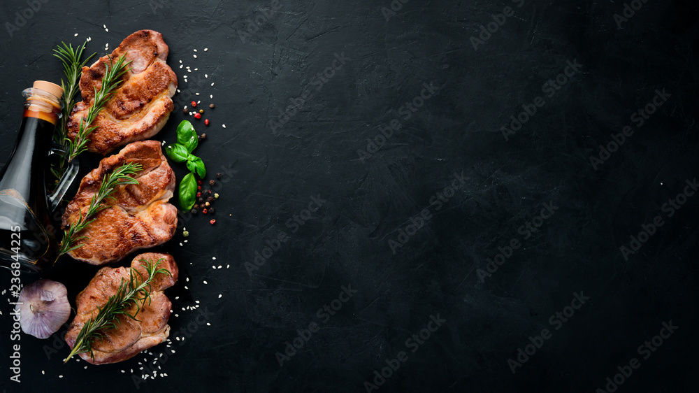 Meat steaks with rosemary. Grill, barbecue. On a black stone background.  Top view. Free copy space. Stock Photo | Adobe Stock