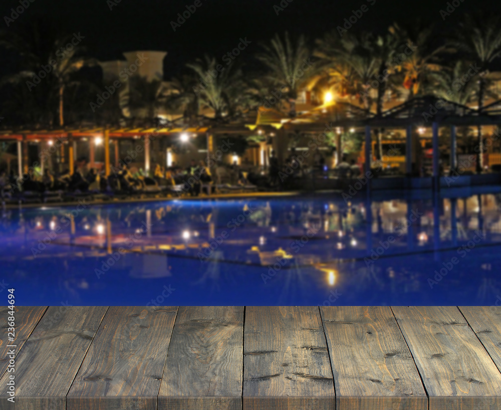 Empty wooden plank with view to evening tropic party. Table top with resort
