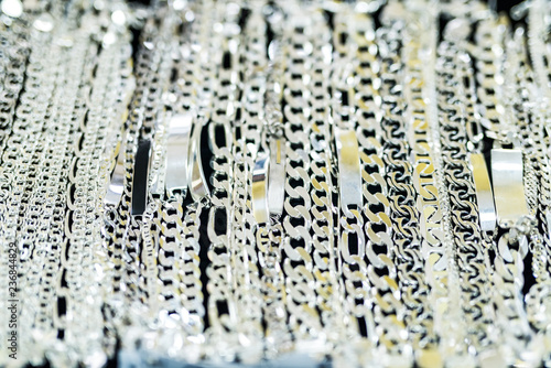 Silver chainlets in showcase of jewellery store photo