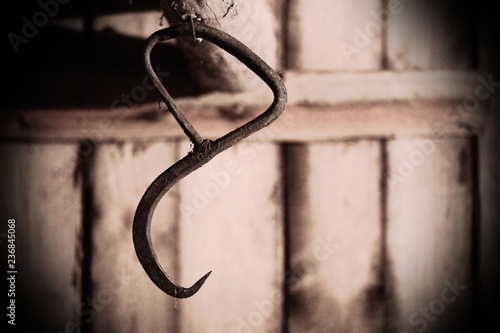 Rusty hook in a grained image and spooky setting