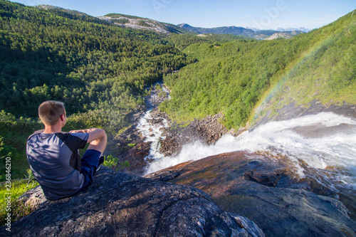 Person an einem Wasserfall, Blick über weite landschaft, Wald