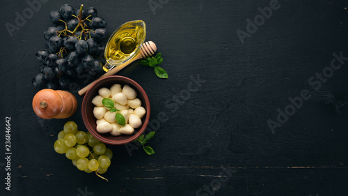 Cherry mozzarella cheese. Top view. On a black wooden background. Free copy space.