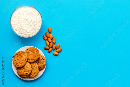 Ingredients for homemade cookies. Fresh cookies near flour on blue background top view copy space
