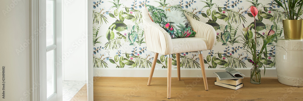 Stylish interior, lovely and bright space to read books or to studdy interior magazines. Floral pattern wallpaper and design armchair. - obrazy, fototapety, plakaty 