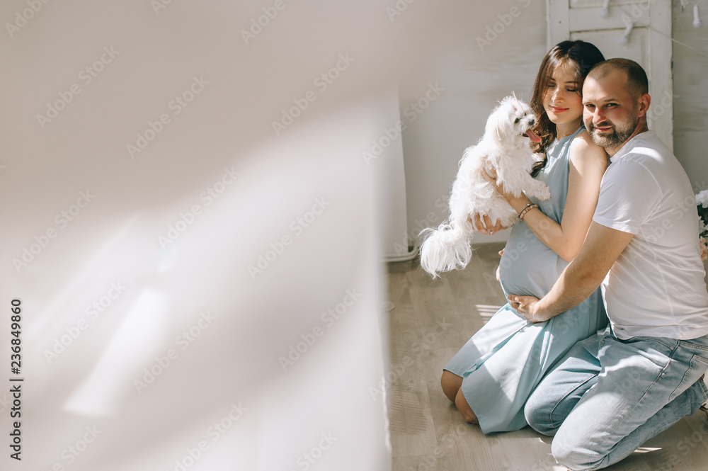 Young couple expecting baby standing together indoors