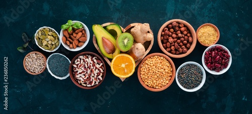 Superfoods Healthy food. Nuts  berries  fruits  and legumes. On a black stone background. Top view. Free copy space.