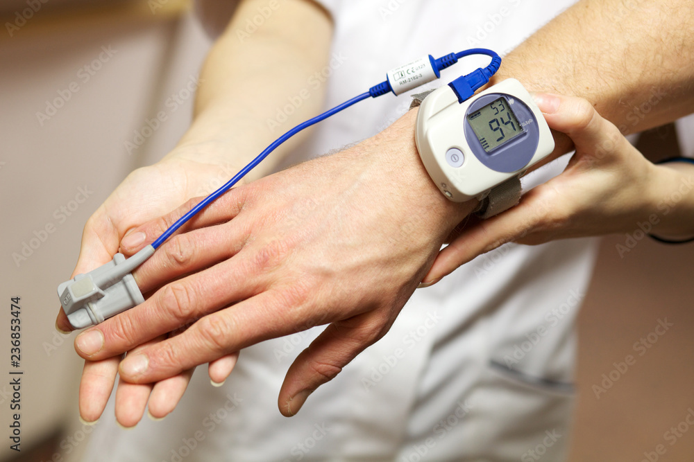 Fototapeta premium A nurse uses a pulse oximeter to monitor a patients oxygen saturation