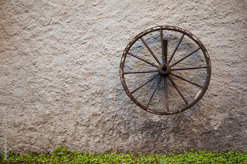 An old wagon wheel displayed on a rustic old wall, Austria