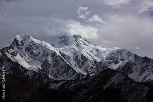 Minya Konka (Mount Gongga, Holy Tibetan Snow Mountain) - Gongga Shan in Sichuan Province, China. View from the west at Yaha Pass, summit shrouded in clouds. Highest Mountain in Sichuan Province China.