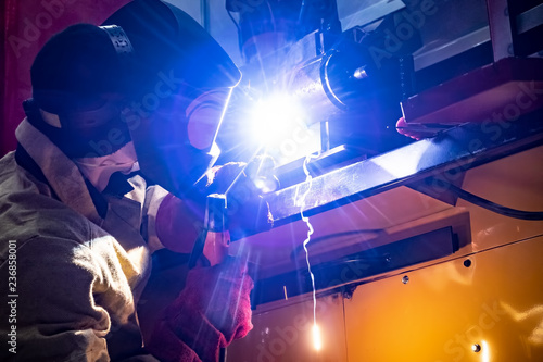 Welding work. A man welds metal. Industrial professions. Welding shop.