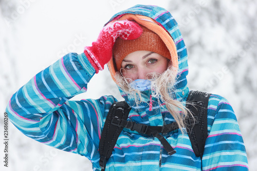 Portrait of a lovely young woman with icy hair covering her face in a bandana from frost