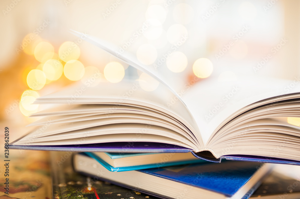 Naklejka premium Open book is on top of the stack on bokeh background