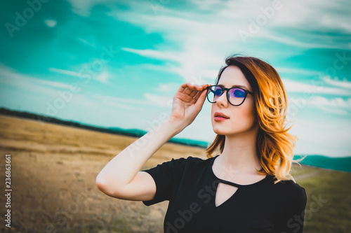Portrait of young woman with eyeglasses at countryside