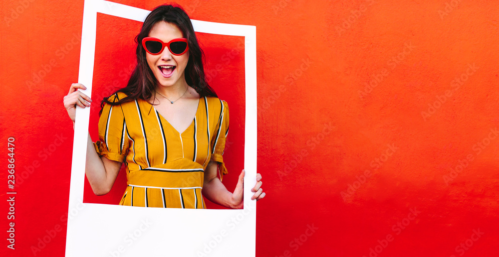 Beautiful woman in sunglasses with blank photo frame - obrazy, fototapety, plakaty 
