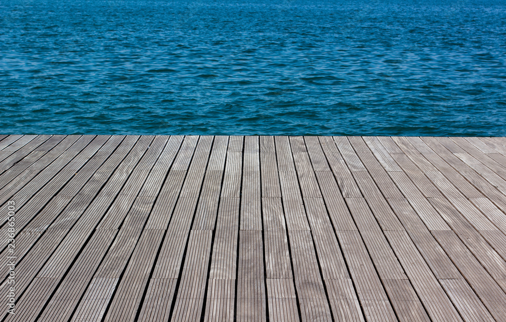 wooden desk waterfront pier floor and fuzzy sea vivid blue and green water background texture, copy space wooden desk waterfront pier floor and fuzzy sea vivid blue and green water background texture, copy space