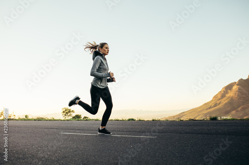 Woman athlete running on road
