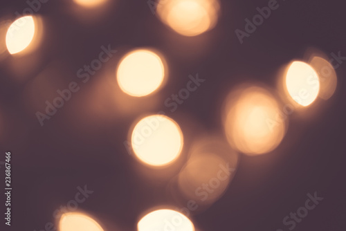 Blurred focus of circular bokeh lights in warm golden tone for abstract background. Seasons greetings, Merry Christmas and Happy New Year celebrations concept.